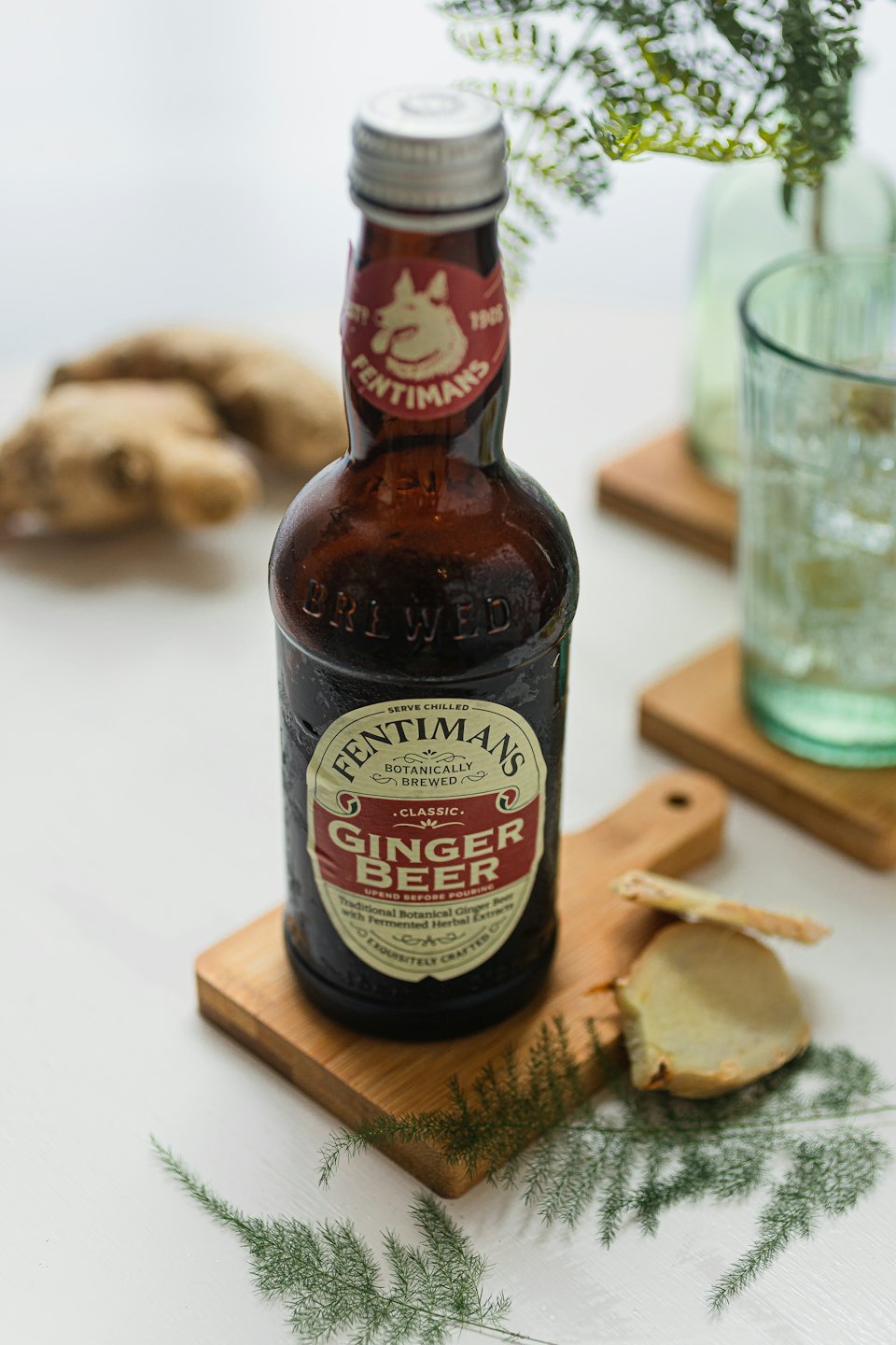 Una botella de cerveza de jengibre sobre un posavasos de madera.